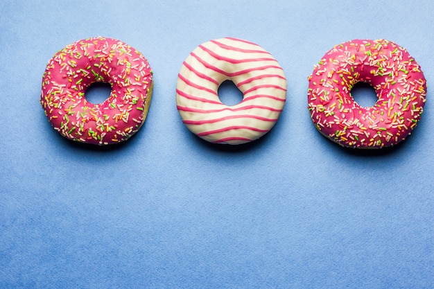 roze geglazuurde donuts op blauwe achtergrond