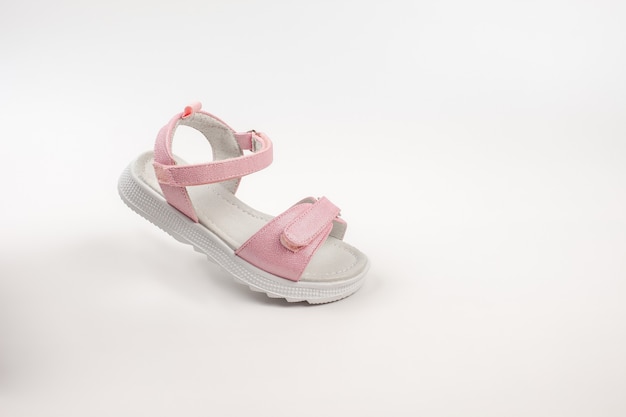 Roze geïsoleerde kindersandalen roze kindersandalen met witte zolen en klittenbandsluitingen geïsoleerd op een w...