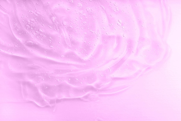 Roze gelvlekachtergrond Hyaluronzuur voor huidverzorging met collageen en retinol Huidverzorgingslotion gezichtsserumstaal Cosmetische crème transparante vloeibare gel Lichaamsverzorging