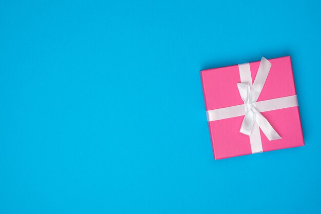 Roze geschenkdoos over blauw oppervlak