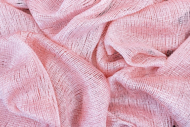 Roze glanzende stoffen achtergrond gevouwen in golvende vouwen
