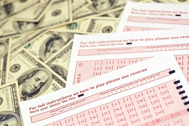 Roze gokbladen met nummers voor markering op grote hoeveelheid honderd-dollarbiljetten Loterijspelconcept of gokverslaving Close-up