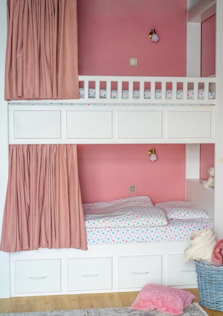 Foto roze gordijnen voor een stapelbed voor meisjes in de slaapkamer zonder mensen