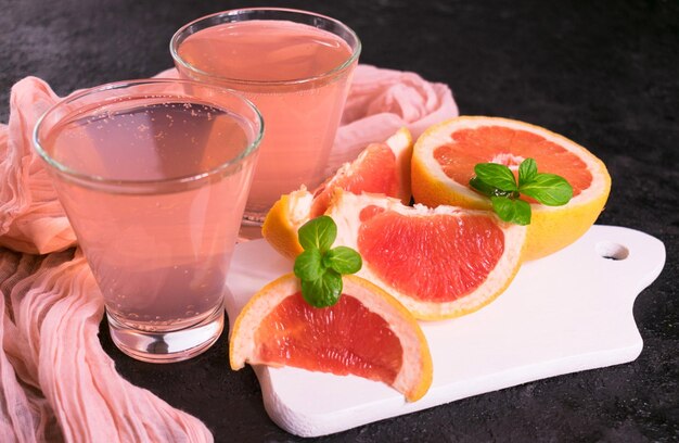 Roze grapefruit en muntdrank op een zwarte achtergrond