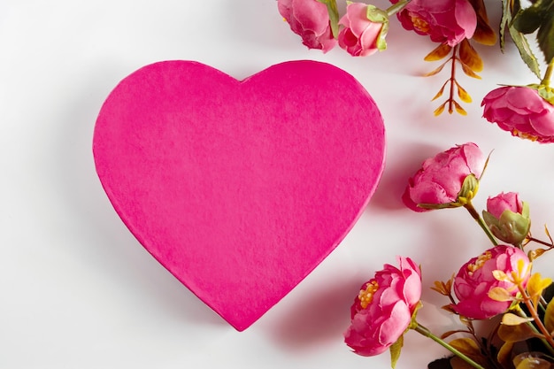 Roze hart voor Valentijnsdag op een achtergrond van bloemen Ontwerp voor Valentijnsdag