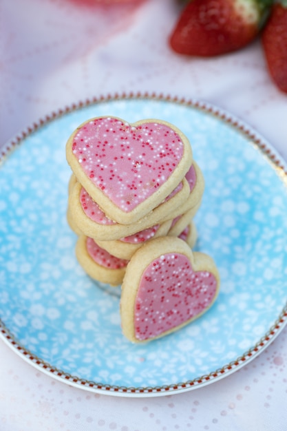 Roze hartvormige koekjes op versierde plaat