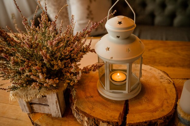 Roze heide in houten doos. herfst decor met kaarsen. witte lantaarn met brandende kaars. huisdecoratie voor een gezellige sfeer.