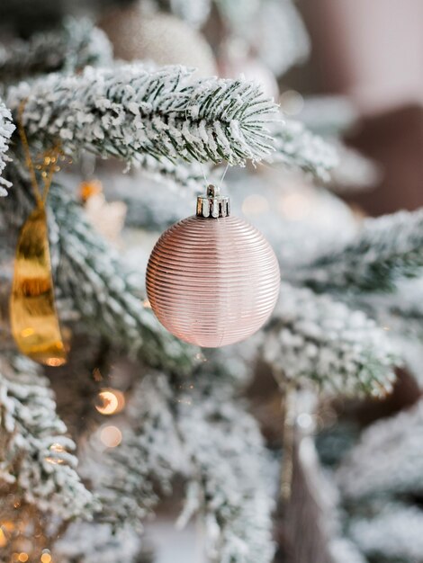 Roze kerstbal die aan een ijzige dennenboom hangt. Vrolijke kerstkaart. Winter kerst thema. Gelukkig nieuwjaar