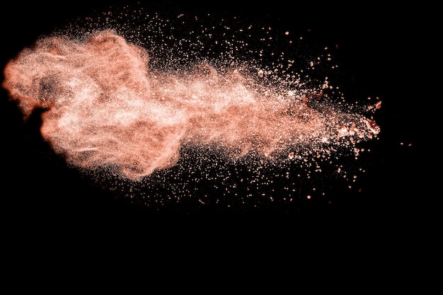 Foto roze kleur poeder explosie op zwarte achtergrond.