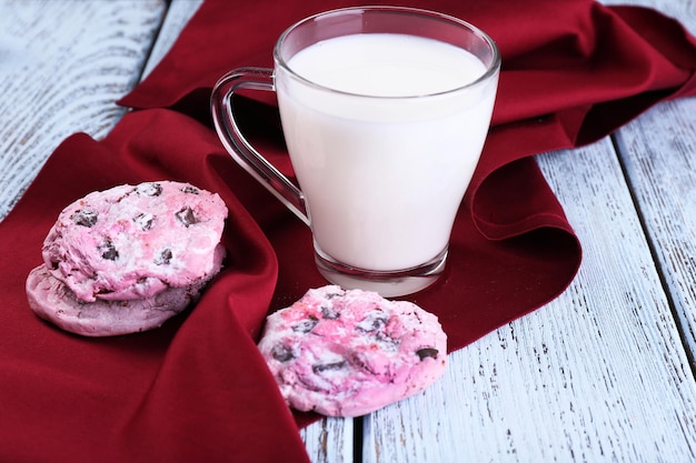 Roze koekjes en beker met melk op tafel close-up