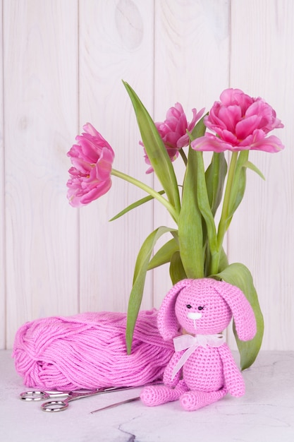 roze konijn met tulpen. St. Valentijnsdag decor. Gebreide speelgoed, amigurumi, wenskaart.