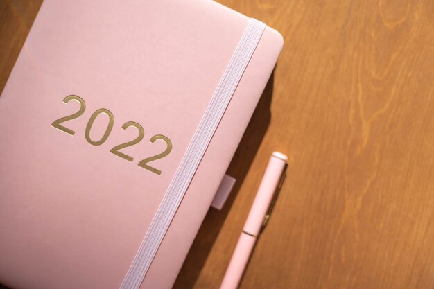 Roze koraalkleurige agenda voor het jaar pen koffie