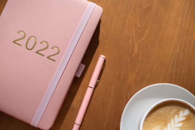 Roze koraalkleurige agenda voor het jaar pen koffie