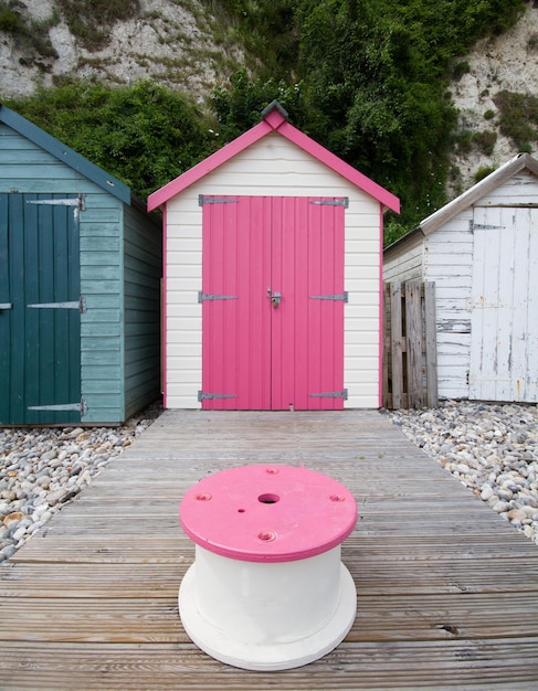 Foto roze kruk tegen een strandhut.