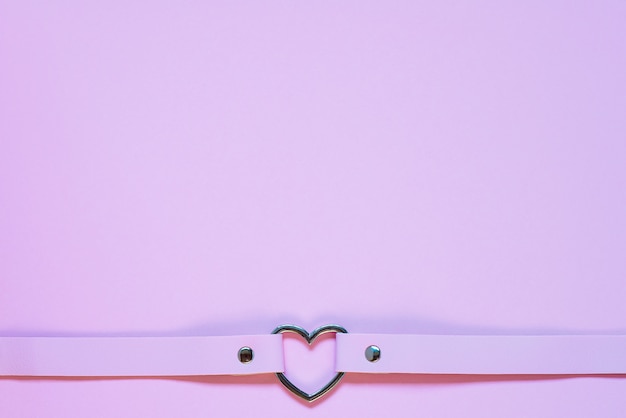 Roze lederen choker met een metalen hart. Valentijnsdag concept.