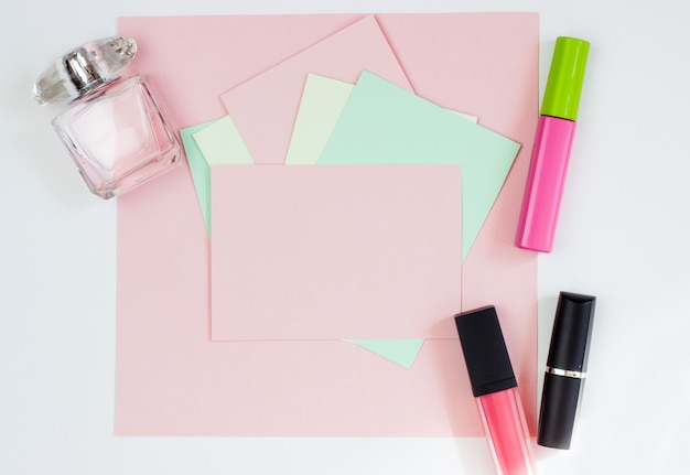 Roze lege kaart, blad om te schrijven. lay-out voor het toevoegen van tags met parfum en lippenstift. bovenaanzicht, plat lag, kopieer ruimte