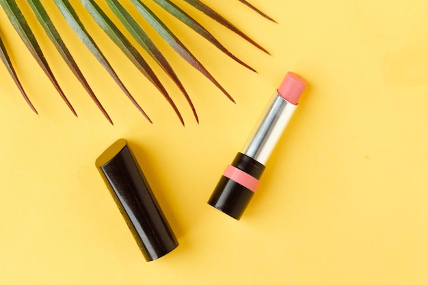 Roze lippenstift op heldergele achtergrond vlakke lay top view minimale schoonheid en cosmetica achtergrond