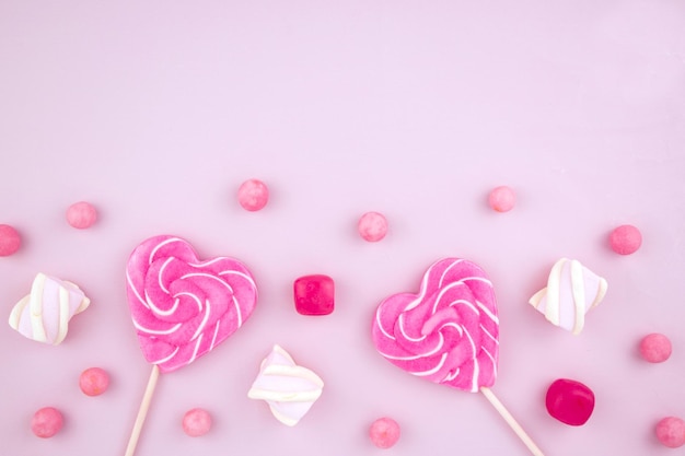 Roze lollies snoep karamel en marshmallow Heldere snoepjes en Valentijnsdag Bovenaanzicht plat oppervlak