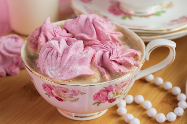 Roze marshmallows in een kopje met koffie. Shabby stijl.