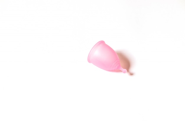 Roze menstruatie cup op witte achtergrond. Plat lag, bovenaanzicht. copyspace