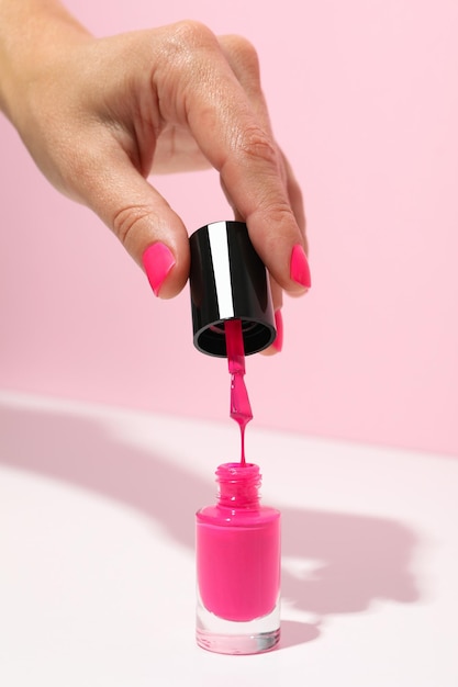 Roze nagellak met een vrouwelijke hand.