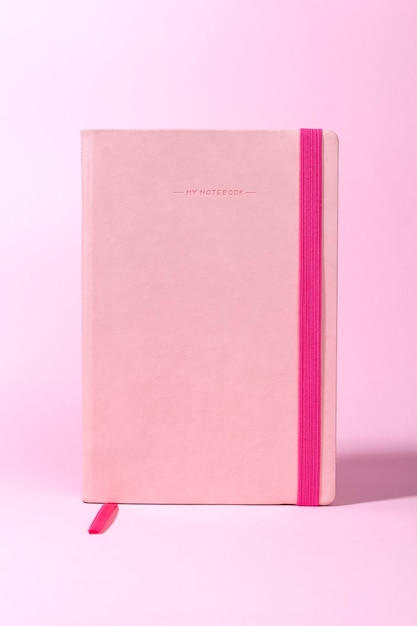 Roze notitieboekje op roze bureaublad