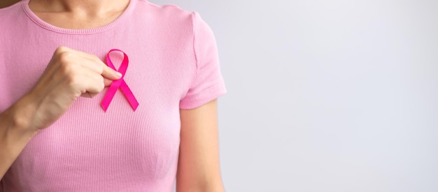 Roze oktober Breast Cancer Awareness maand vrouw hand houden roze lint en draag shirt voor ondersteuning van mensen leven en ziekte Nationale kankeroverlevenden maand Moeder en Wereld kanker dag concept