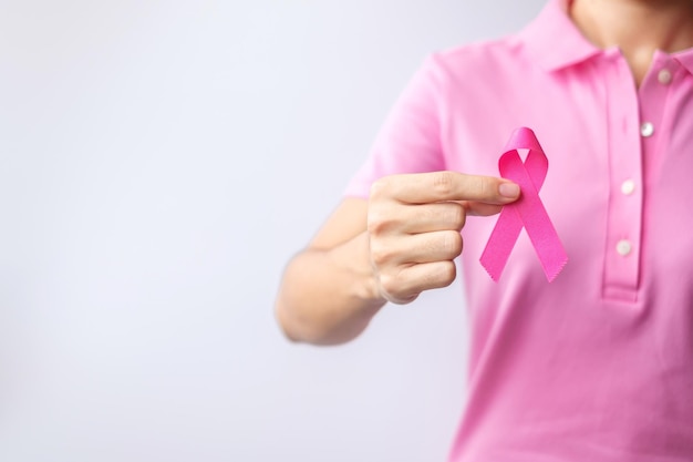 Roze oktober breast cancer awareness maand vrouw hand houden roze lint en draag shirt voor ondersteuning van mensen leven en ziekte nationale kankeroverlevenden maand moeder en wereld kanker dag concept