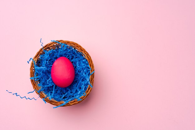 Roze paasei in een nest op roze achtergrond