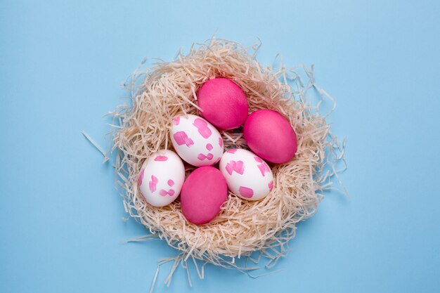 Roze paaseieren met aquarel penseelstreken op een blauwe ondergrond