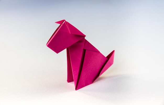 Roze papieren hond origami geïsoleerd op een lege witte achtergrond.