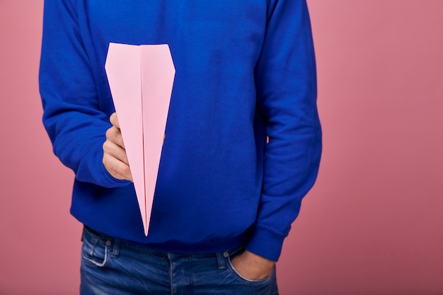 roze papieren vliegtuigen in man hand