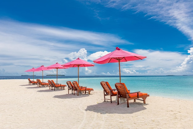 Roze parasol en stoelen op tropisch strand. Geweldige paradijselijke eilandkust, witte zandblauwe zeelucht