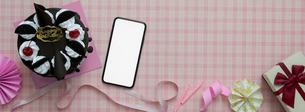 Roze patroon achtergrond met smartphone, cake, decoraties