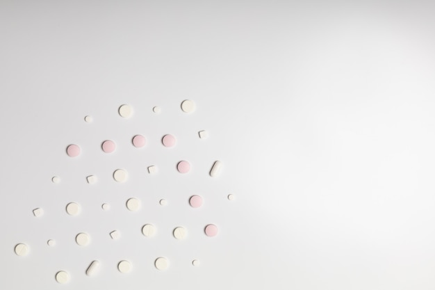 Roze pillen op witte achtergrond, richting