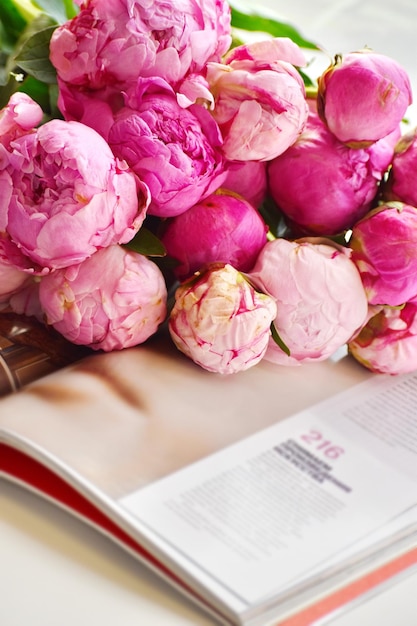 Roze pioenrozen en boek Je favoriete boek lezen Bloemen achtergrond Bloemen liggen op open boek