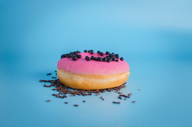 Roze ronde doughnut bij heldere blauwe achtergrond