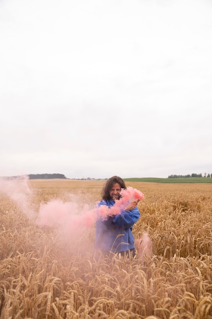 Foto roze rook achtergrond met jonge volwassene