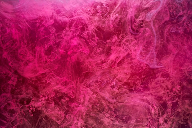 Roze rook op zwarte inktachtergrond, kleurrijke mist, abstracte wervelende aanraking oceaanzee, acrylverfpigment onder water