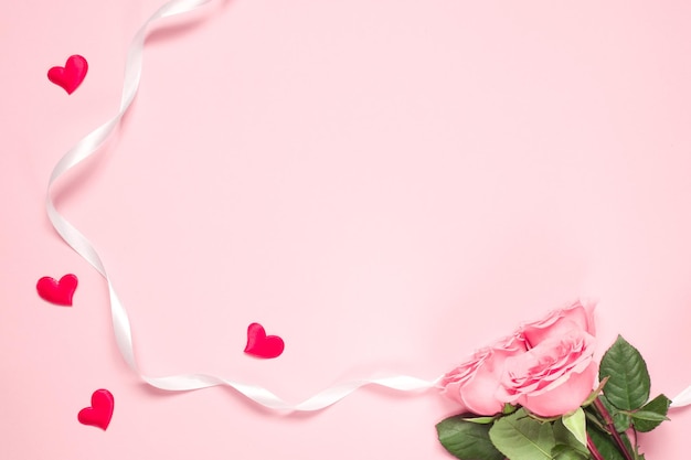 Roze rozen anf lint met kleine hartjes op penk achtergrond Kaart voor 8 maart vrouwendag Kopieer ruimte mock up banner