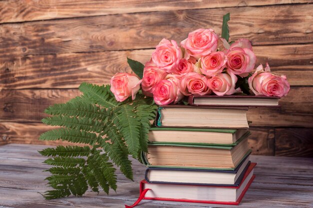 Foto roze rozen en boeken op een houten achtergrond