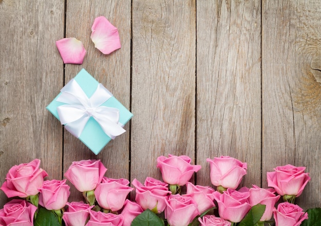 Roze rozen en Valentijnsdag geschenkdoos over houten tafel