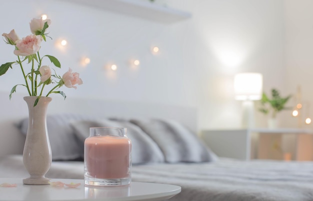 Roze rozen in vaas op tafel in slaapkamer