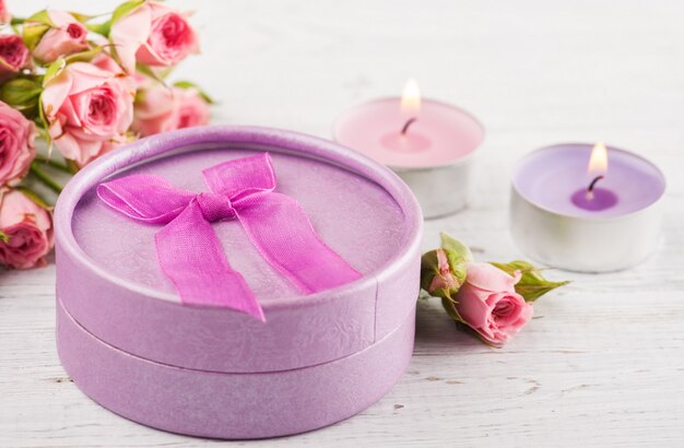 Roze rozen met cadeau en kaarsen