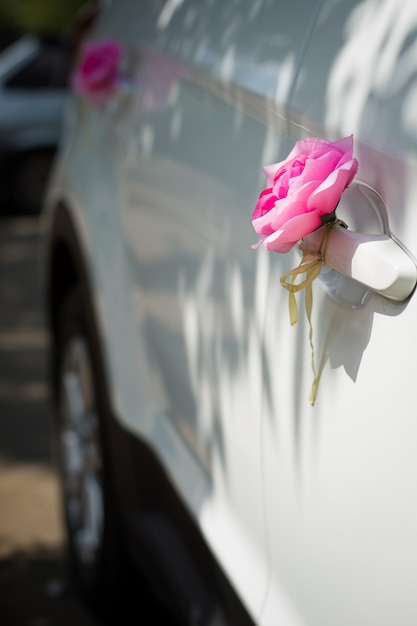 Roze rozen op de deur van de huwelijksauto