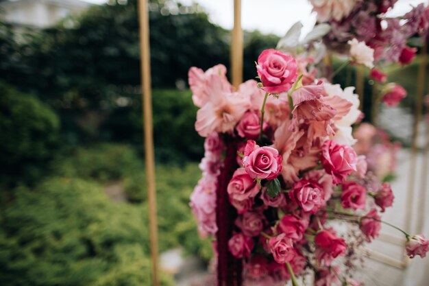 Roze rozen op de huwelijksboog bij de huwelijksceremonie