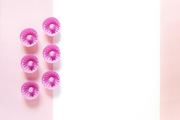Roze siliconen mallen voor cupcakes en muffins op een roze en witte ondergrond