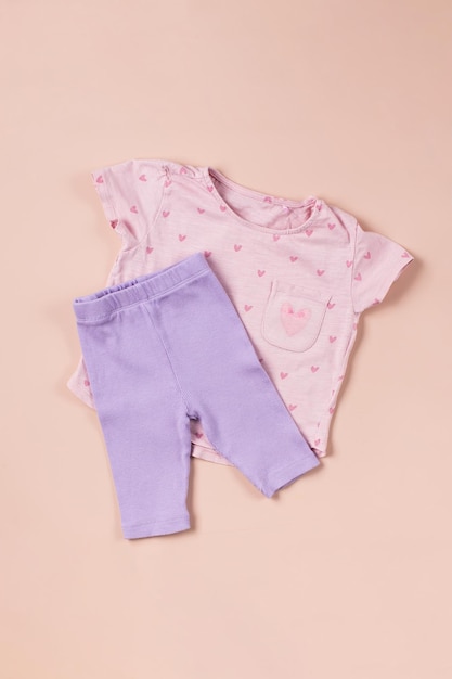 Roze t-shirt voor kinderen en lila shorts op een roze achtergrond een modieus sportief beeld voor een meisje flat lay