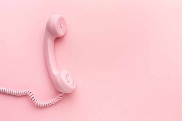 Roze telefoonhoorn op roze achtergrond