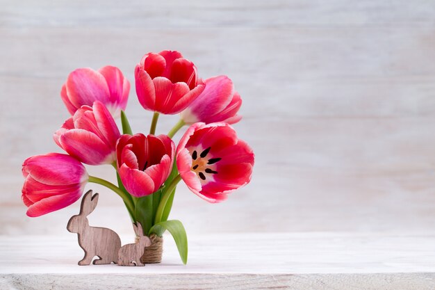 Roze tulpen, lentebloemen en paasdecoratie.